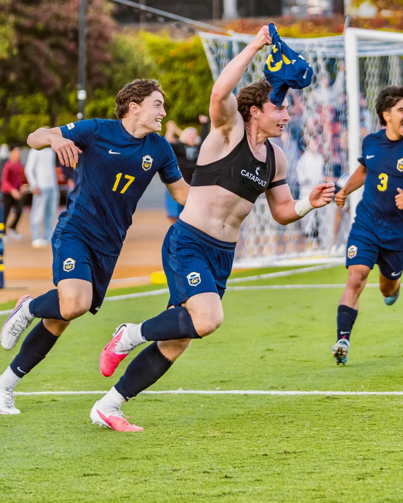 Kai, shirtless, with brother Miko (17) after scoring a last-minute goal against UCLA